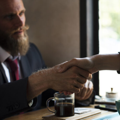 Business agreement handshake at coffee shop